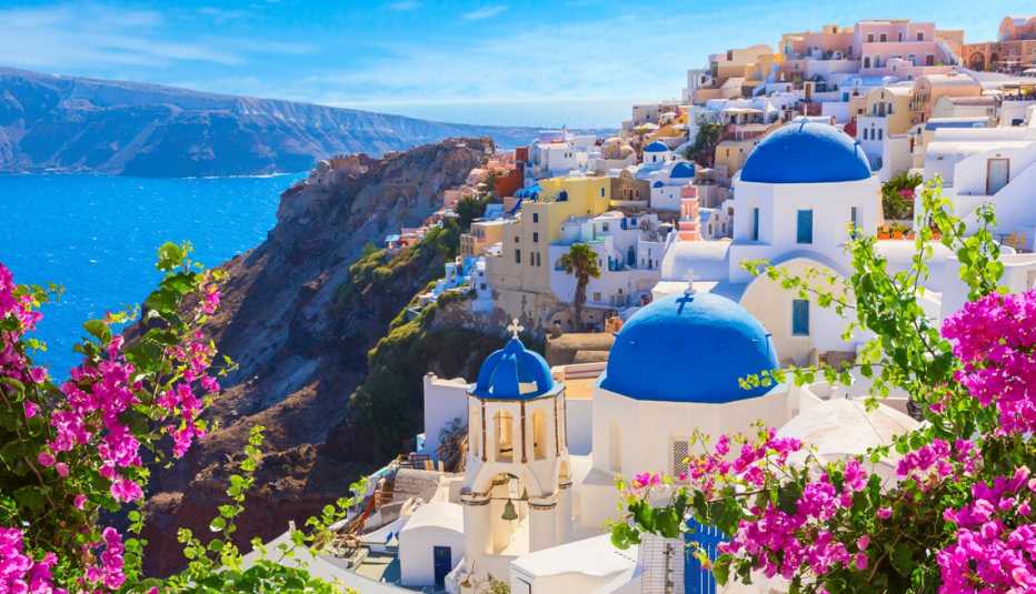 Flores frente a pintorescas edificaciones con techos azules en una isla