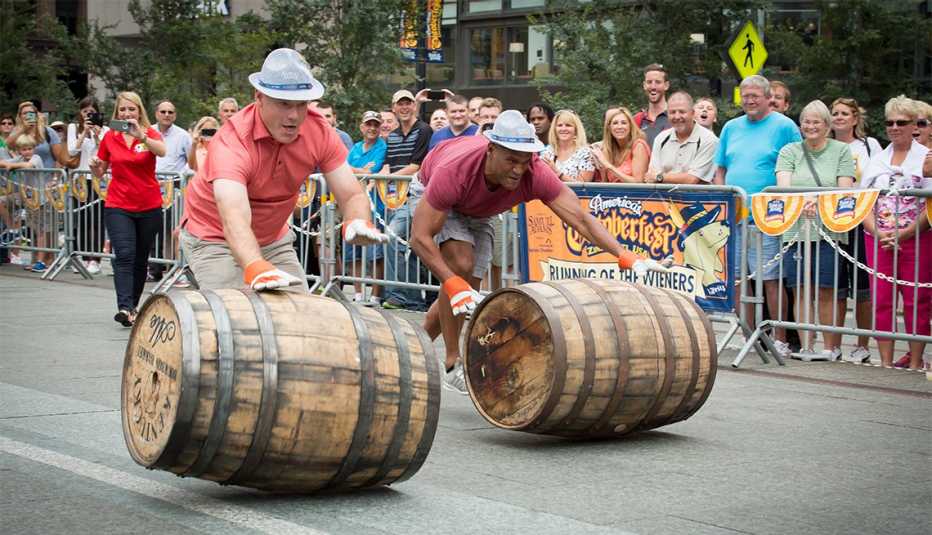 Hombres ruedan barriles de madera en el festival Oktoberfest Zinzinatti