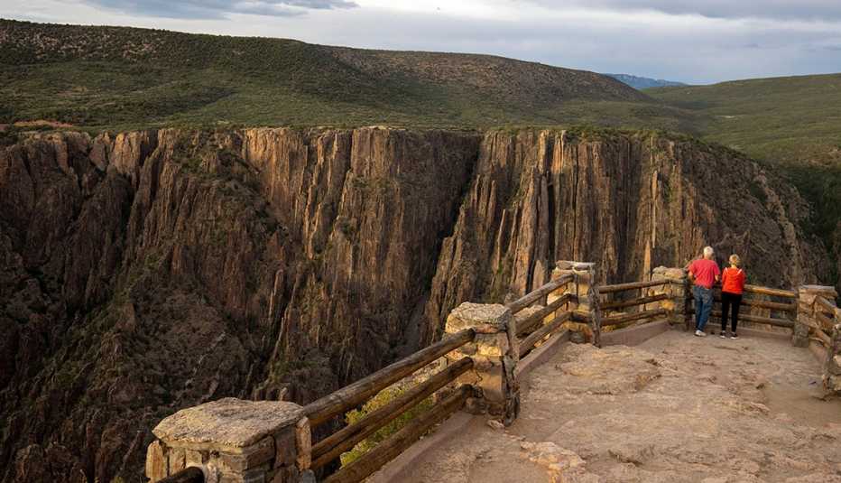 Dos visitantes observan el Parque Nacional Cañón Negro del Gunnison en Colorado desde un mirador
