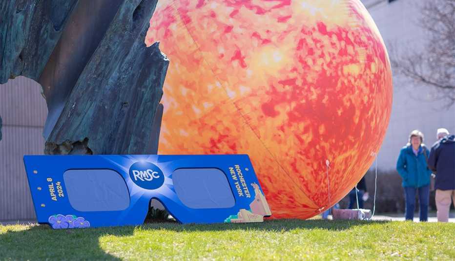 gafas para ver eclipses y un sol inflable en las afueras del Rochester Museum and Science Center en Nueva York