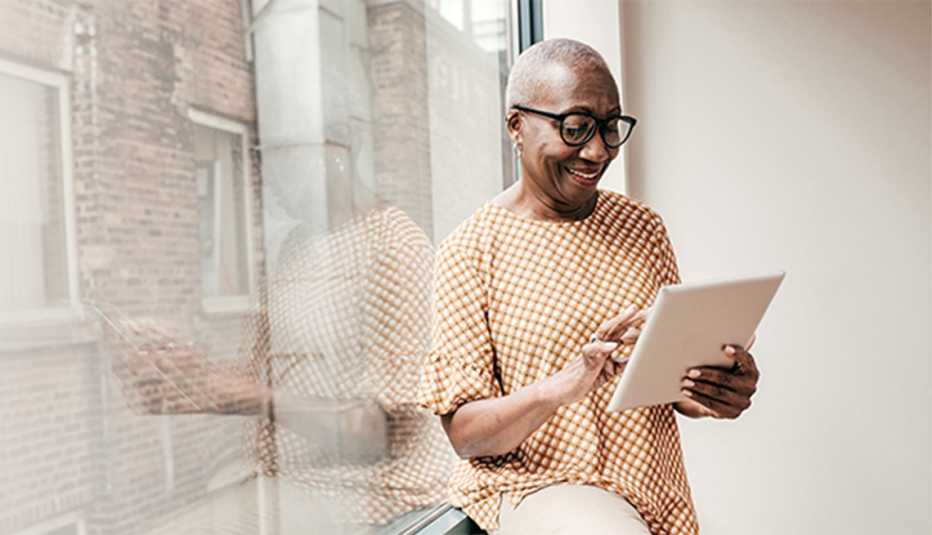 A woman using a tablet inside by a window