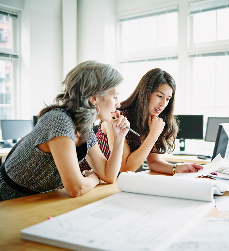 two women at a desk working on a project together