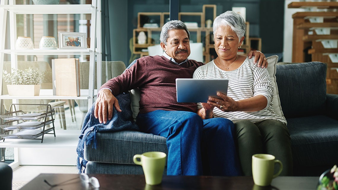 couple on couch looking at tablet