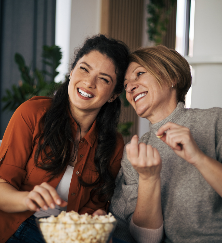 women eating popcorn and watching a movie