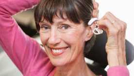 Una mujer se alista para colocarse un audífono