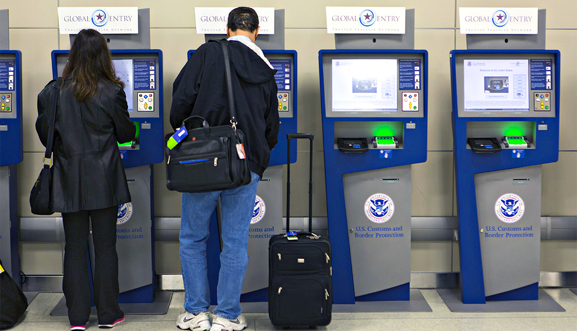 Dos personas hacen proceso inmigración en unas máquinas de un aeropuerto de Estados Unidos.
