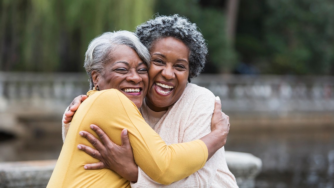two women hugging and smiling happy to see each other