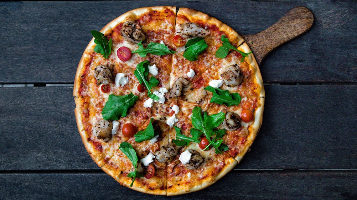 whole pizza with toppings on wood table