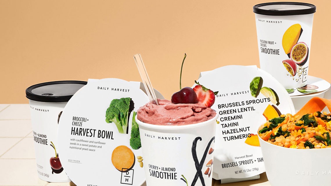 cups, bowl containers of daily harvest food including rice dish and cherry strawberry smoothie