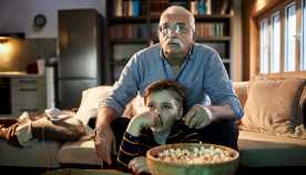 Close up of a grandfather watching a movie with his grandson