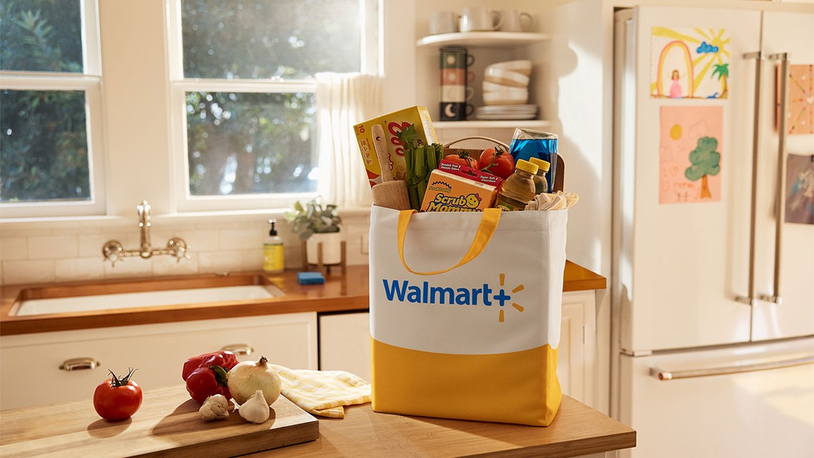 kitchen scene with an island where a full of groceries yellow and white with Walmart+ logo bag is sitting