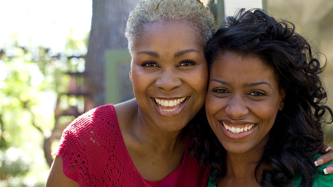 Dos mujeres sonriendo al aire libre.