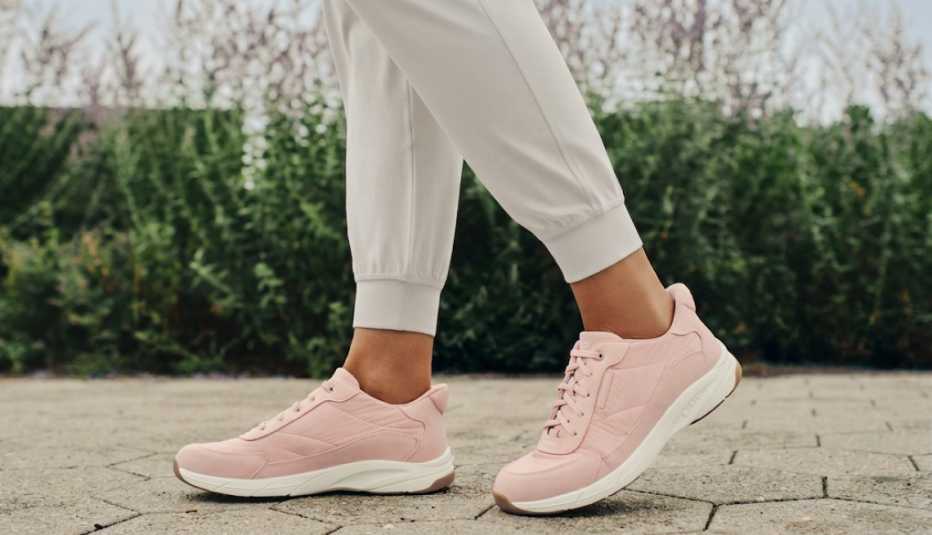 Close-up view of pink walking shoes on a paved outdoor path.