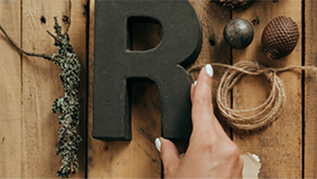 A woman's hand touching an "R"