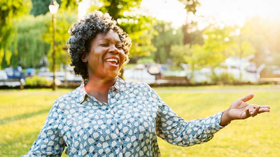 A woman outside smiling and laughing