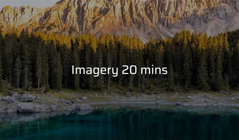 A body of water with trees and mountains in the background 