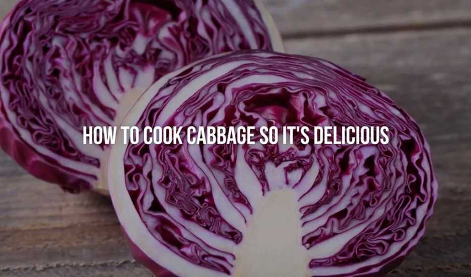 A close-up view of two cabbages on a wooden surface with the text "how to cook cabbage so it's delicious"