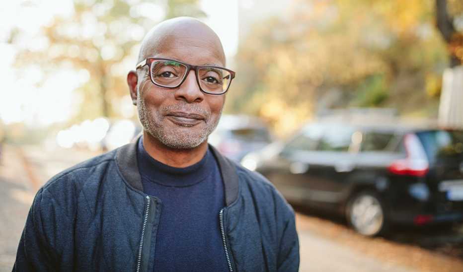A portrait shot of a man smiling while standing in the road
