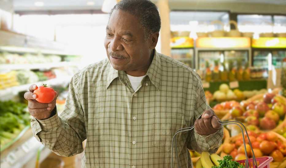 A man shopping for produce at a grocery store