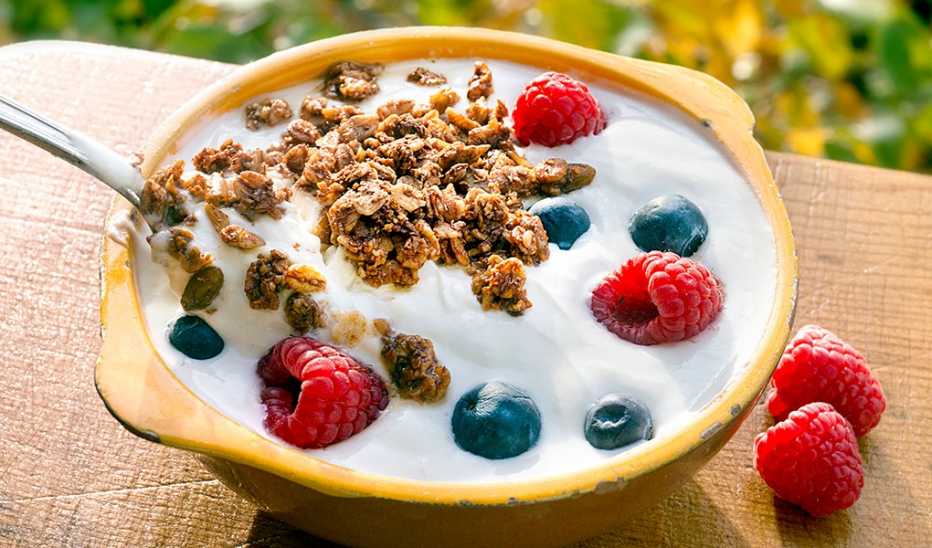 A close-up view of a yogurt with berries and granola
