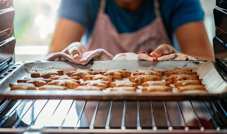 A person taking cookies out of the oven