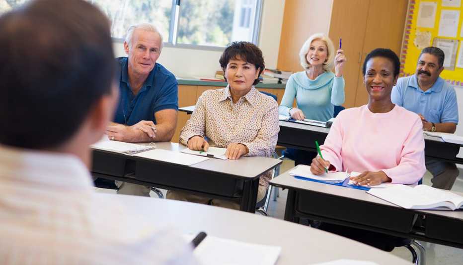 A group of adults sitting at desks in a classroom
