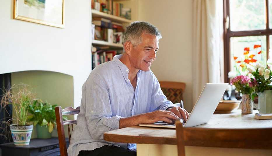 Man sitting at table using laptop