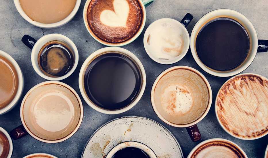 An aerial view of various mugs full of coffee