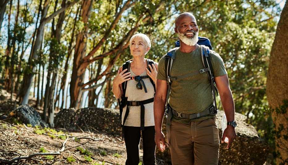 A man and woman hiking together in a wooded area