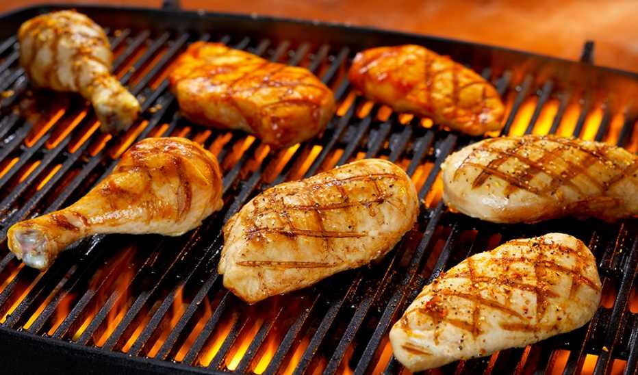 An up-close view of chicken breasts and legs on a grill