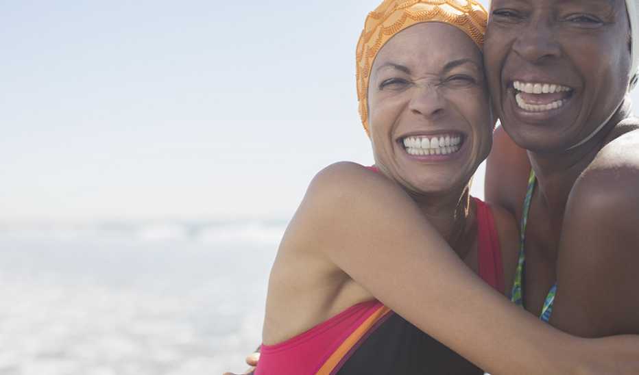 Two female swimmers smiling and hugging