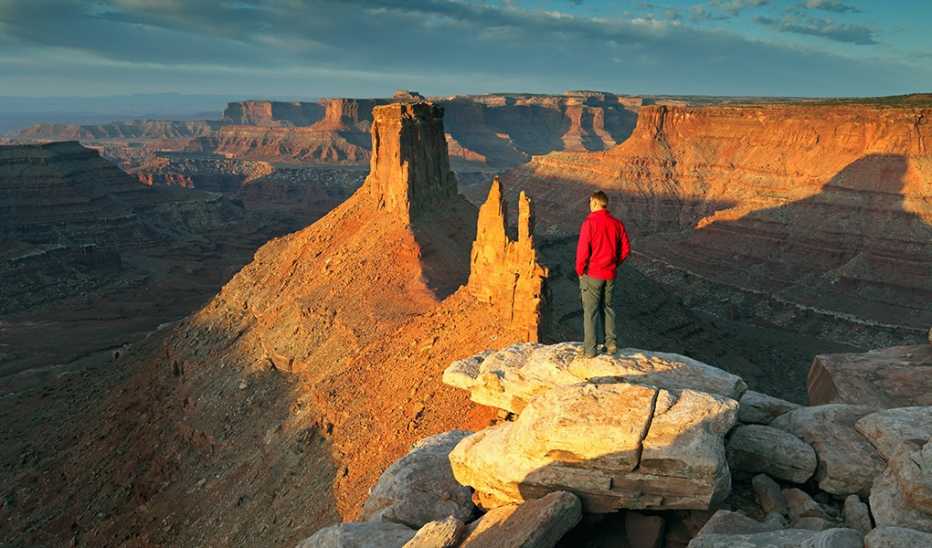A man standing on the cliff of a canyon