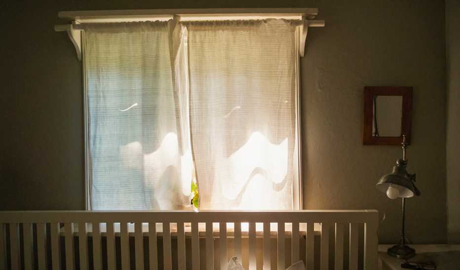 A dark bedroom with its window curtains closed