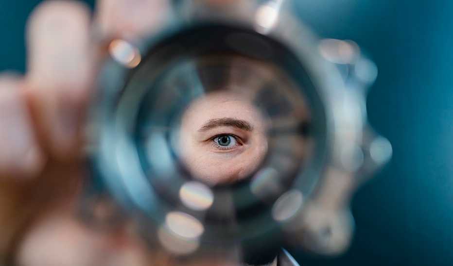 The eye of a man looking through a pipe