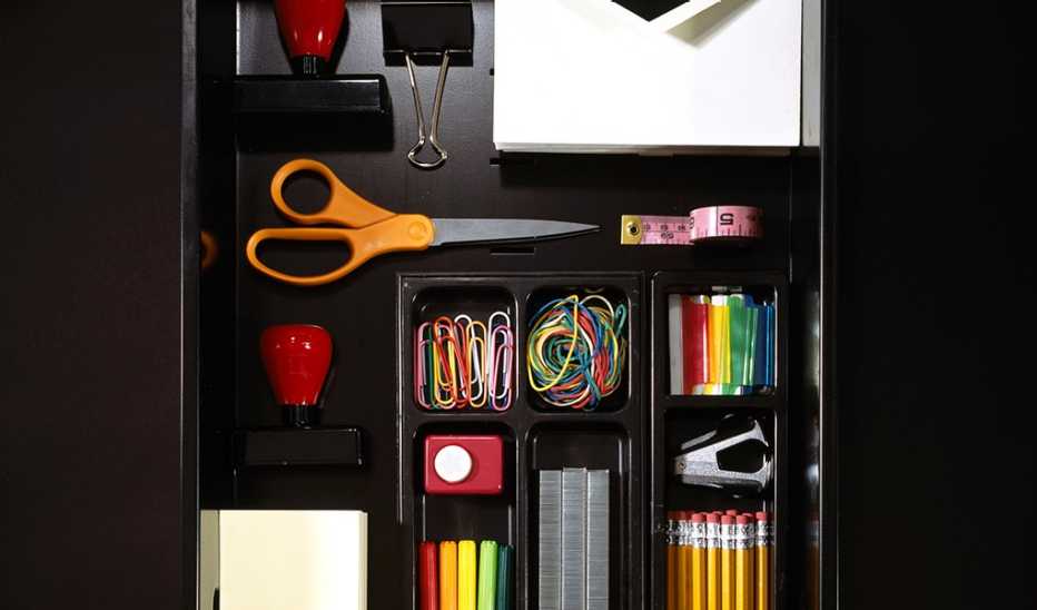 An organized desk drawer with pencils, pens, stapler and more