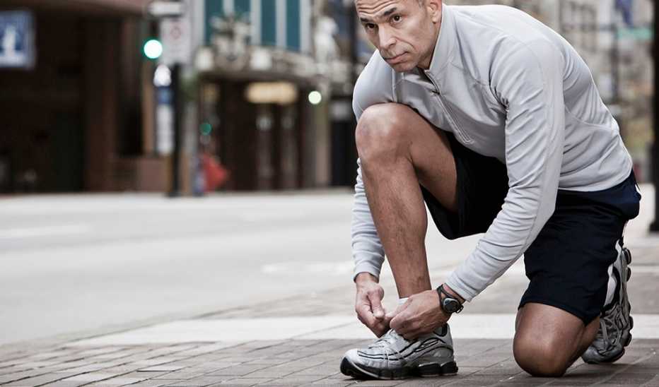 A runner taking a knee to tie his shoe
