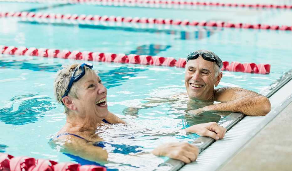A man and woman hanging on the wall inside an indoor pool