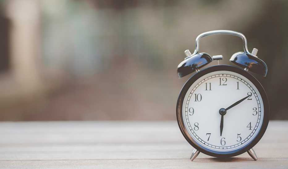 Retro alarm clock sitting on wooden table