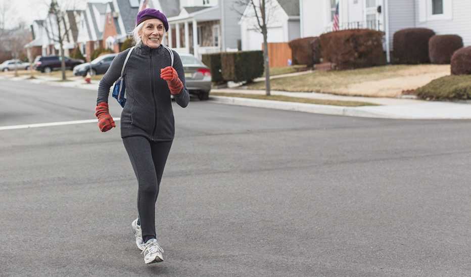 A woman power walking through a neighborhood