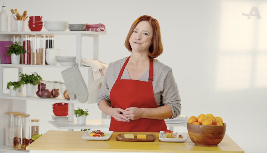 A woman standing in front of a few plates of healthy snacks