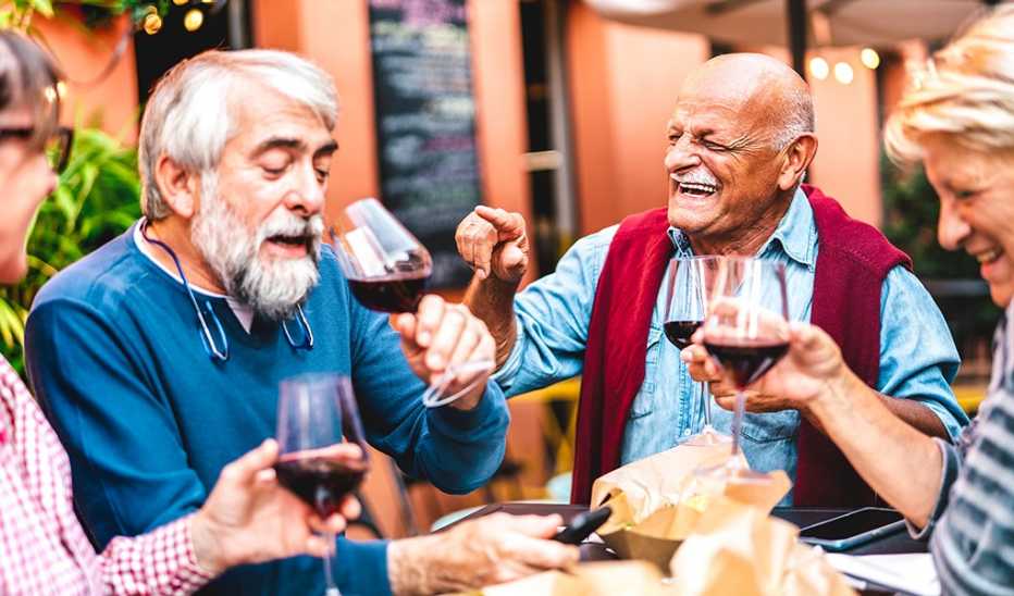 A group of male and female friends drinking wine together at a restaurant