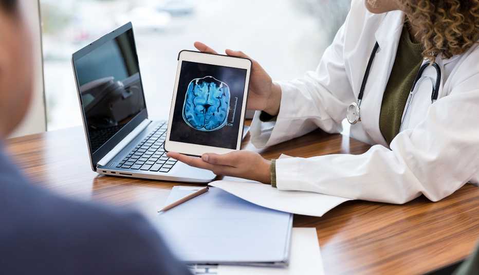 A female doctor showing a male patient a tablet with an image of a brain from an MRI scan