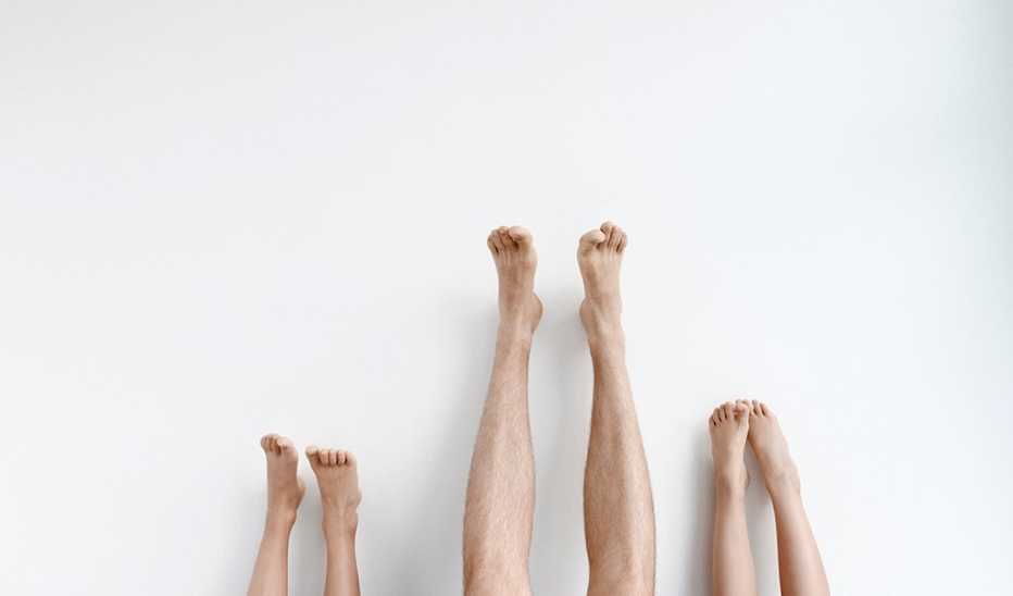 Three pairs of legs raised up against a wall