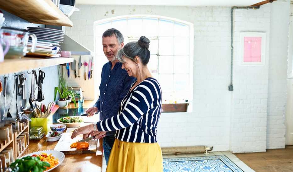 Maintaining healthy boundaries involves balancing your own well-being with others A man and woman chopping vegetables in a kitchen
