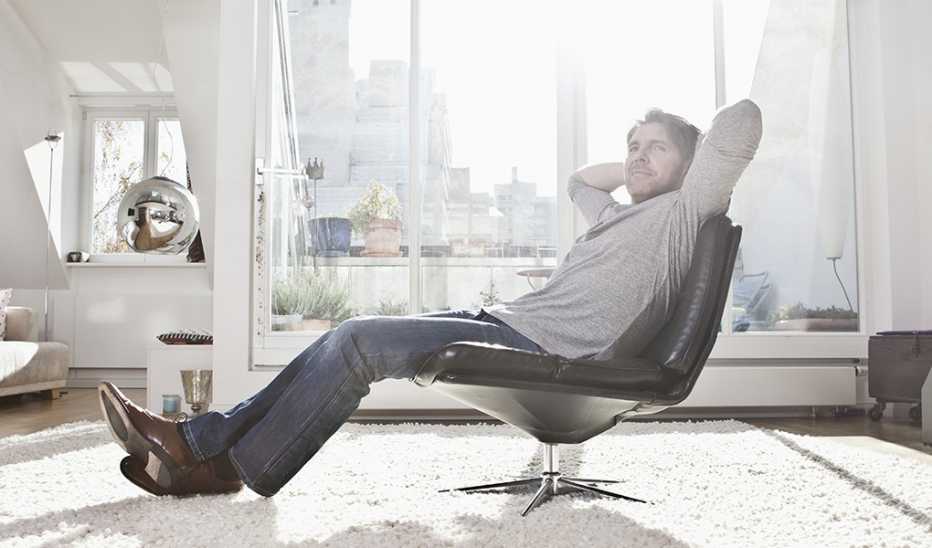 A man leaning back in a chair inside a building in a city