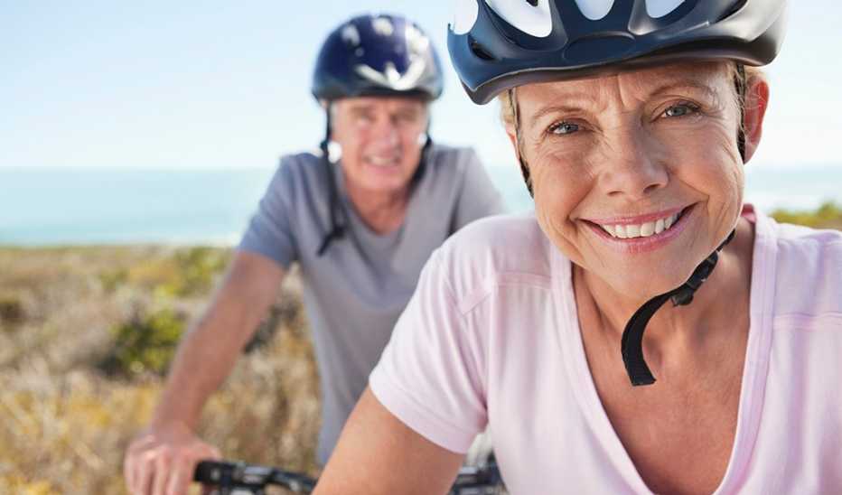 A man and woman smiling together on bicycles