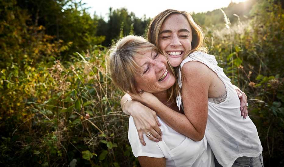 A mother and daughter hugging in the countryside