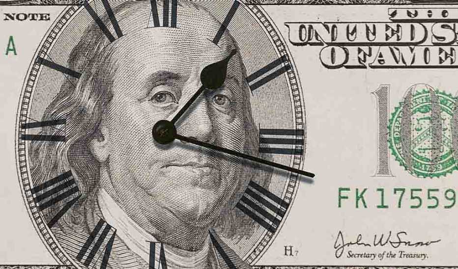 An up-close view of a $100 bill with a clock on it