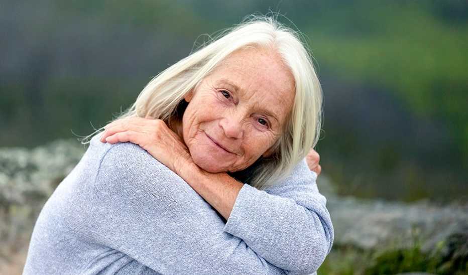 A portrait shot of a woman smiling outside 