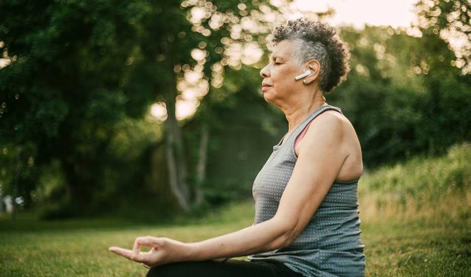 Side view of woman sitting outside in a lotus position